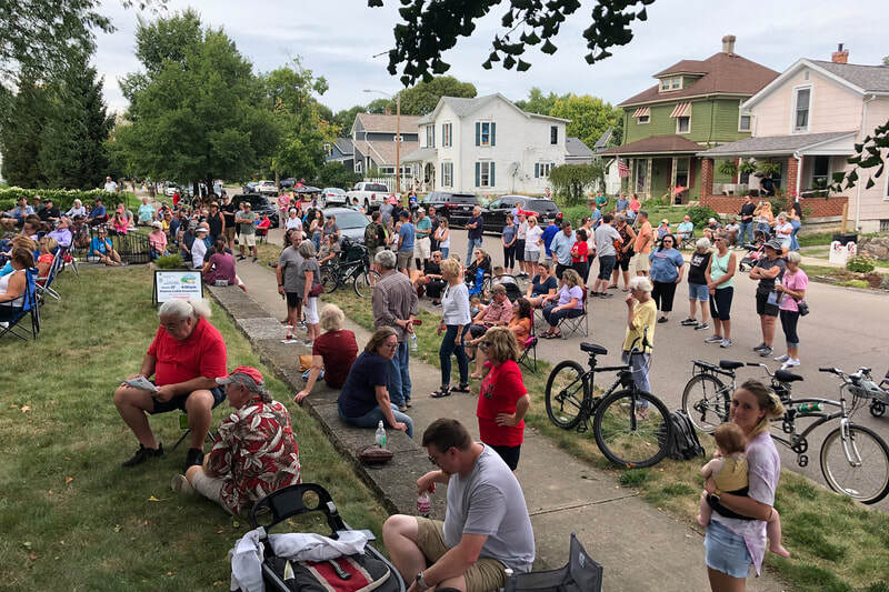 A large crowd covers the yard and the the street at a concert in Troy Ohio
