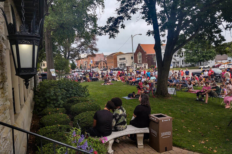 A crowd formed for Porch Fest in front of the Troy Hayner Cultural Center on a beautiful summer day in 2024